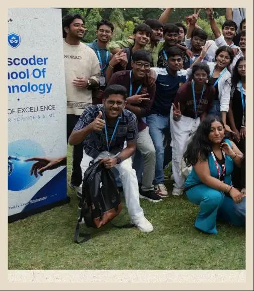 Batch photo on the campus lawn beside the Bosscoder School of Technology banner